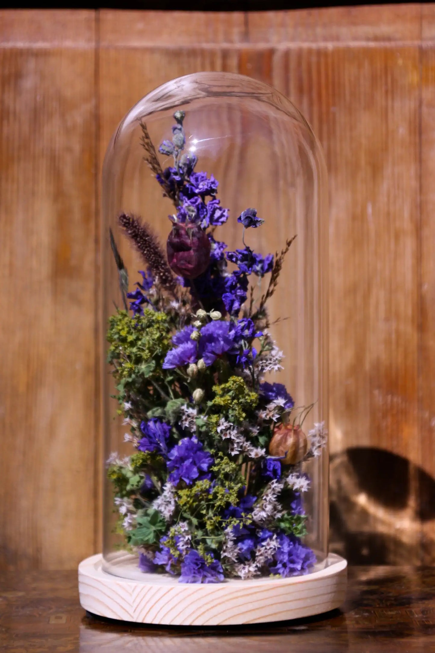 Cloche de fleurs séchées aux couleurs chaudes, idéale pour une décoration d'automne.