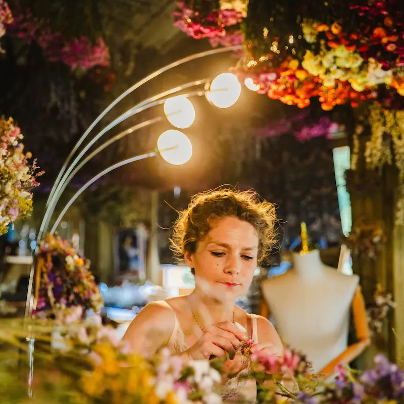 Charlotte en trian de composer une couronne murale dans le séchoir de la ferme florale en Normandie, dans le cadre d'un stage fleurs séchées. 