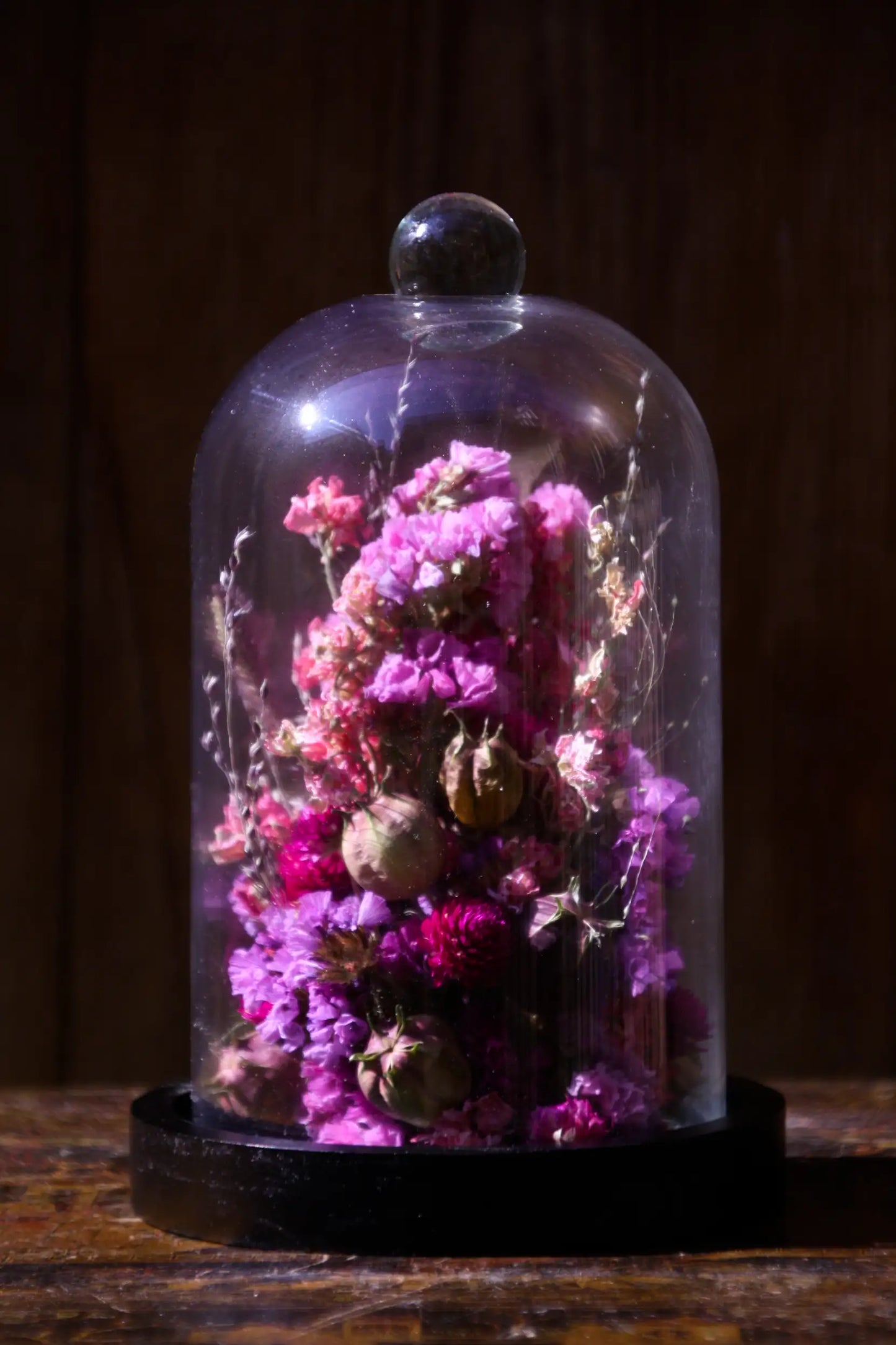 Composition printanière de fleurs séchées sous cloche pour une touche de fraîcheur.