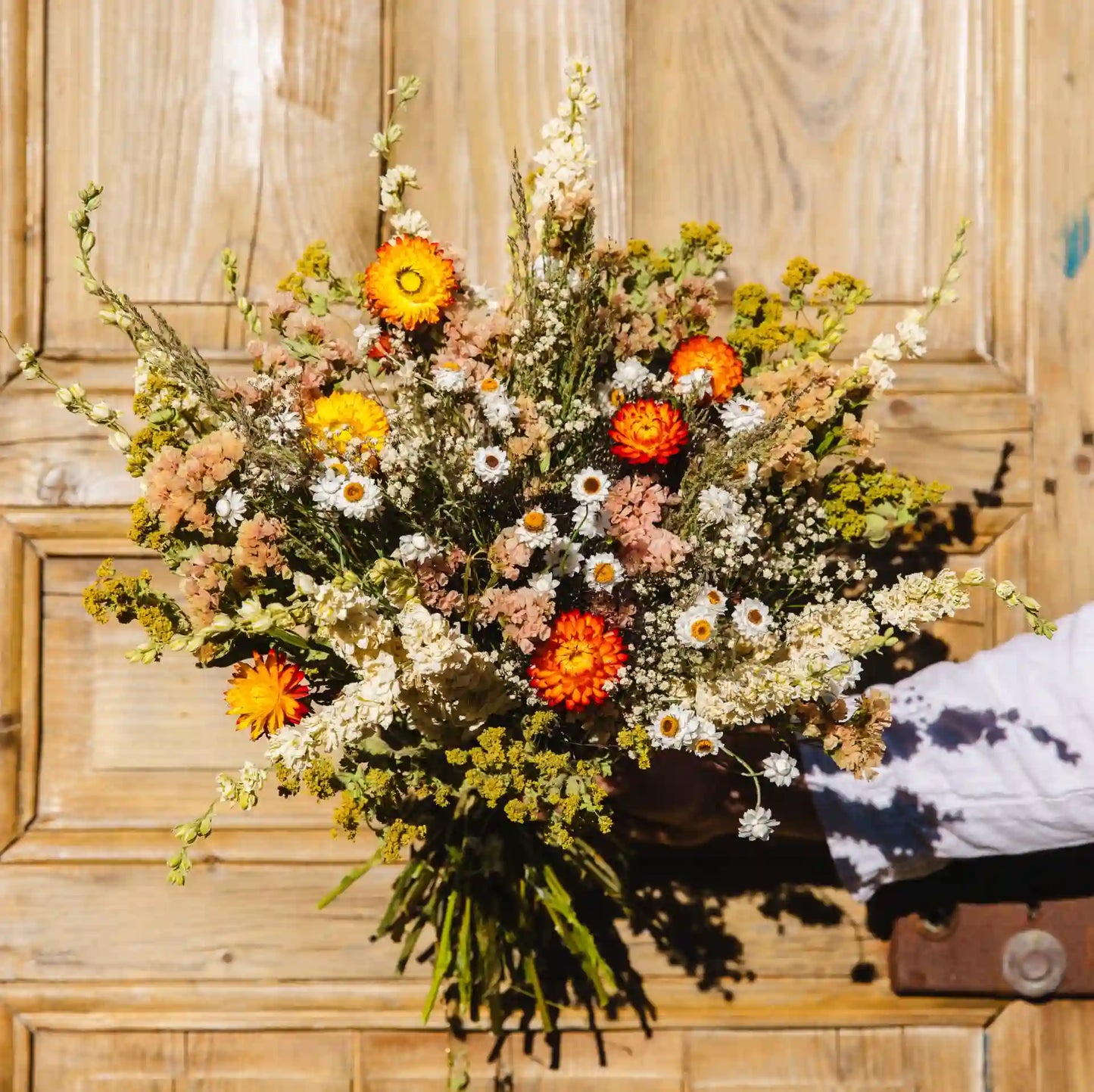 Grand bouquet de fleurs séchées chaleureux tons pêche et saumon Bayeux, porté par une fleuriste
