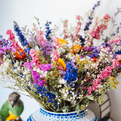 Bouquet de fleurs séchées multicolores Granville dans un vase transparent sur une table de salon
