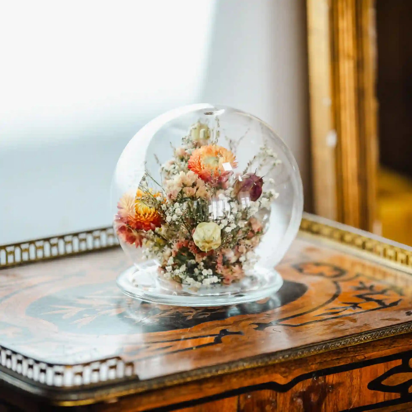 Cloche sphérique en verre décorative avec fleurs séchées tons pêche saumon Bayeux