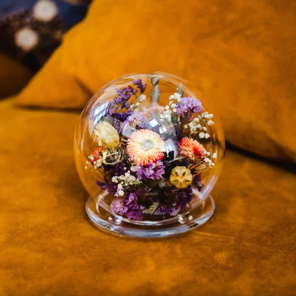 Bulle sphérique en verre élégante avec fleurs séchées teintes parme et saumon Deauville