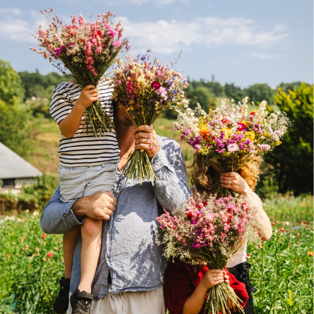 Jeune couple de mariés avec leurs enfants et des beaux bouquets, réalisés par Fleurs de la Clarté, fleuriste mariage à Dozulé