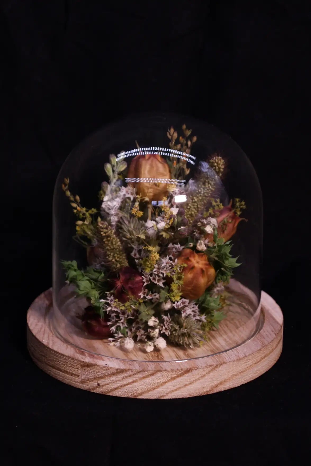 Petite cloche minimaliste garnie de fleurs séchées aux tons pastel et très doux.