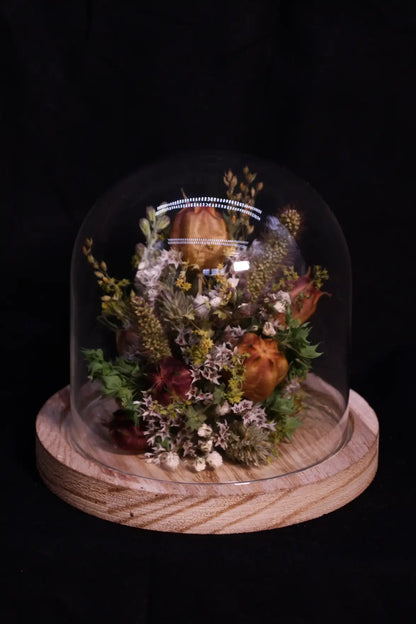 Petite cloche minimaliste garnie de fleurs séchées aux tons pastel et très doux.