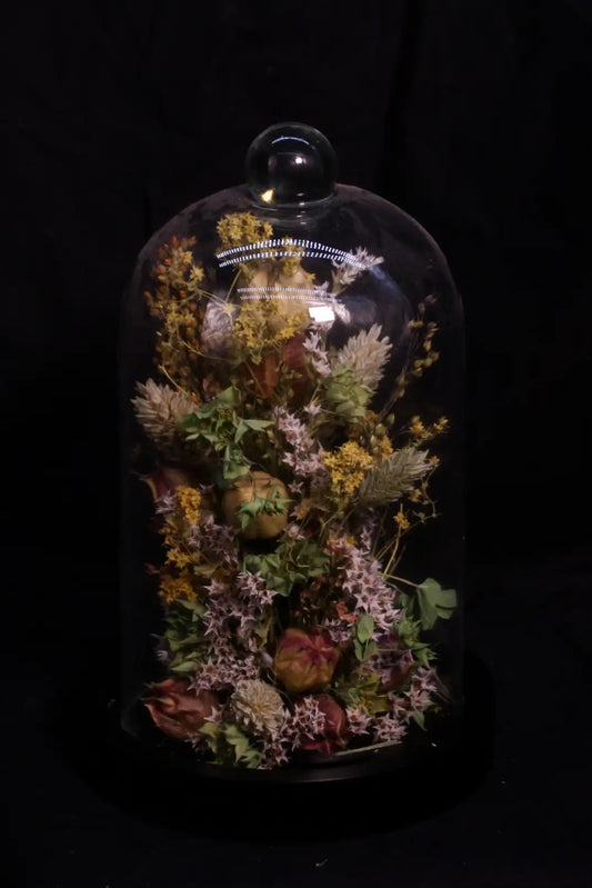 Centre de table de mariage artisanal sous forme de cloche de fleurs séchées naturelles.